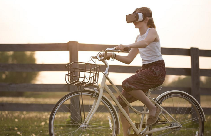 A girl cycling wearing a VR head